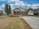 Brick ranch home with a spacious driveway and small front yard at 1205 Danielle Downs Ct, Concord, NC 28025