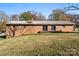 Back view of a brick ranch home with a sloping backyard and a small back deck at 1705 Enochville Rd, Kannapolis, NC 28081