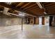 Unfinished basement with exposed beams and brick accent wall at 1705 Enochville Rd, Kannapolis, NC 28081