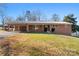 Single-story brick home with attached carport and grassy front yard at 1705 Enochville Rd, Kannapolis, NC 28081