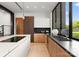 Modern kitchen with dark countertops, wood cabinets, and a large window at 237 Marsh Rd # 101, Charlotte, NC 28209