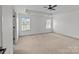 Bright bedroom with neutral carpet, two windows, and ceiling fan at 3392 Brackhill St, Davidson, NC 28036