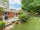 Brick home with wooden deck and a nicely manicured lawn at 11214 Sudbury Rd, Davidson, NC 28036