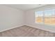 Bright bedroom with neutral walls, carpet, and a large window offering a view at 118 Brixham Loop, Troutman, NC 28166