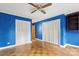 Blue bedroom with wood flooring, ceiling fan, and built-in closets at 702 Forest Hill Dr, Shelby, NC 28150