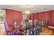Dining room with glass table, hardwood floors, and red walls at 702 Forest Hill Dr, Shelby, NC 28150