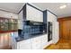 Kitchen features white cabinets, blue tile backsplash, and modern appliances at 702 Forest Hill Dr, Shelby, NC 28150