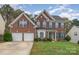 Brick two-story house with a three-car garage and landscaped lawn at 2060 E Foxwood Ct, Lancaster, SC 29720