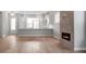 Open living room featuring hardwood floors, modern fireplace, and kitchen island at 1031 Seven Sisters Ave, Monroe, NC 28110