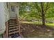 Wooden steps leading to a fenced backyard with a large tree at 405 7Th St, Spencer, NC 28159