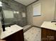 Bathroom with walk-in shower, dual vanity, and geometric tile at 2216 Tate St, Charlotte, NC 28216