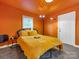 Bright bedroom with orange walls and a cozy yellow bed at 2015 Pinckney Ave, Charlotte, NC 28205