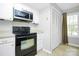 Kitchen with black stove, microwave, and white cabinets at 9408 Vicksburg Park Ct, Charlotte, NC 28210