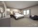 Main bedroom with plush bed, comfortable seating, and large windows at 3032 Summit Oaks Rd, Charlotte, NC 28269