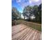 Wooden deck overlooks a large backyard with mature trees at 176 Hunters Glen Rd, Troy, NC 27371