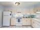 Bright eat-in kitchen with white cabinetry and appliances at 1300 Reece Rd # 302, Charlotte, NC 28209