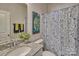 Single vanity bathroom with granite countertop and patterned shower curtain at 311 Coronado Ave # 62, Matthews, NC 28104