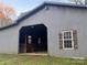 Gray barn with open stalls and a dog inside at 1409 Trinity Church Rd, Monroe, NC 28112