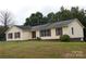 Ranch style home with neutral siding, red shutters, and a landscaped lawn at 8885 Brandon Cir, Concord, NC 28025