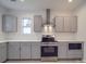 Modern kitchen with gray cabinets, quartz countertops, and stainless steel appliances at 560 Geneva Cir, Gastonia, NC 28056