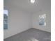 Well-lit bedroom with grey carpet and window at 560 Geneva Cir, Gastonia, NC 28056