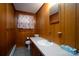 Clean bathroom with wood paneling, vanity, toilet and shower at 900 Nance St, Kannapolis, NC 28083