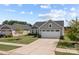 Gray house with a two-car garage, and nicely landscaped yard at 6114 Bellastead Dr, Charlotte, NC 28214