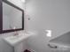 Modern bathroom with pedestal sink, mirror, and dark wood frame at 558 Geneva Cir, Gastonia, NC 28056
