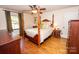 Bright bedroom with hardwood floors, a wooden post bed, and a view of the backyard at 120 Bost St, Statesville, NC 28677