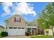 Tan house with white garage doors and red shutters at 8928 Carneros Creek Rd, Charlotte, NC 28214
