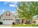 Tan house with white garage doors and red shutters at 8928 Carneros Creek Rd, Charlotte, NC 28214