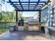 Outdoor kitchen with built-in grill, pergola, and stone countertops at 2716 Manor Stone Way, Indian Trail, NC 28079