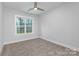 Simple bedroom with neutral walls, carpet flooring, and large window at 2305 Sanders Ave, Charlotte, NC 28216
