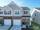 Two-story townhome with gray siding, two-car garage, and small front porch at 13111 Cottage Crest Ln, Charlotte, NC 28273