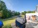 Backyard patio with grill, seating, and wooded backdrop at 13111 Cottage Crest Ln, Charlotte, NC 28273