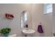 Small powder room with pedestal sink, arched mirror, and white fixtures at 13111 Cottage Crest Ln, Charlotte, NC 28273