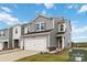 Two-story townhome with gray siding, two-car garage, and landscaping at 3750 County Down Ave, Kannapolis, NC 28081