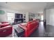 Open living room featuring red leather couches, dark hardwood floors, and a modern electric fireplace at 1517 Kimberly Rd, Charlotte, NC 28208