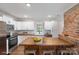 Modern kitchen featuring white cabinets, butcher block island, and exposed brick wall at 305 N Watterson St, Kings Mountain, NC 28086