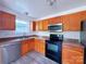 Kitchen with wood cabinets, stainless steel appliances, and vinyl flooring at 5115 Rosemede Dr, Charlotte, NC 28227