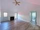 Living room with vaulted ceiling, fireplace, and vinyl flooring at 5115 Rosemede Dr, Charlotte, NC 28227