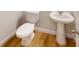 Simple bathroom with white toilet and pedestal sink, wood-look flooring at 515 Tates Trl # 39, Cramerton, NC 28032