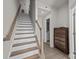 Modern staircase with wooden railing and neutral tones at 912 Broad River Ln, Charlotte, NC 28211