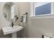 Small bathroom with pedestal sink and oval mirror at 15010 Caspian Way, Charlotte, NC 28278