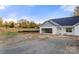 New construction home with an open garage, gravel driveway, and fenced yard at 6201 Bud Huey Rd, Waxhaw, NC 28173