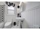 Clean bathroom with pedestal sink, white wainscoting, and marble floor at 109 N York St, Lancaster, SC 29720