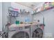 Bright laundry room with washer, dryer, and ample storage shelving at 1036 Lakeland Ave, Lincolnton, NC 28092