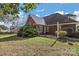 Brick patio with fire pit and grill, surrounded by lush landscaping at 2488 Birdie Ne Ln, Conover, NC 28613
