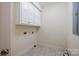 Laundry room with upper cabinets and tile flooring at 2488 Birdie Ne Ln, Conover, NC 28613