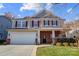 Two-story house with gray siding, red brick accents, and a metal roof at 659 Hosta Dr, Fort Mill, SC 29715